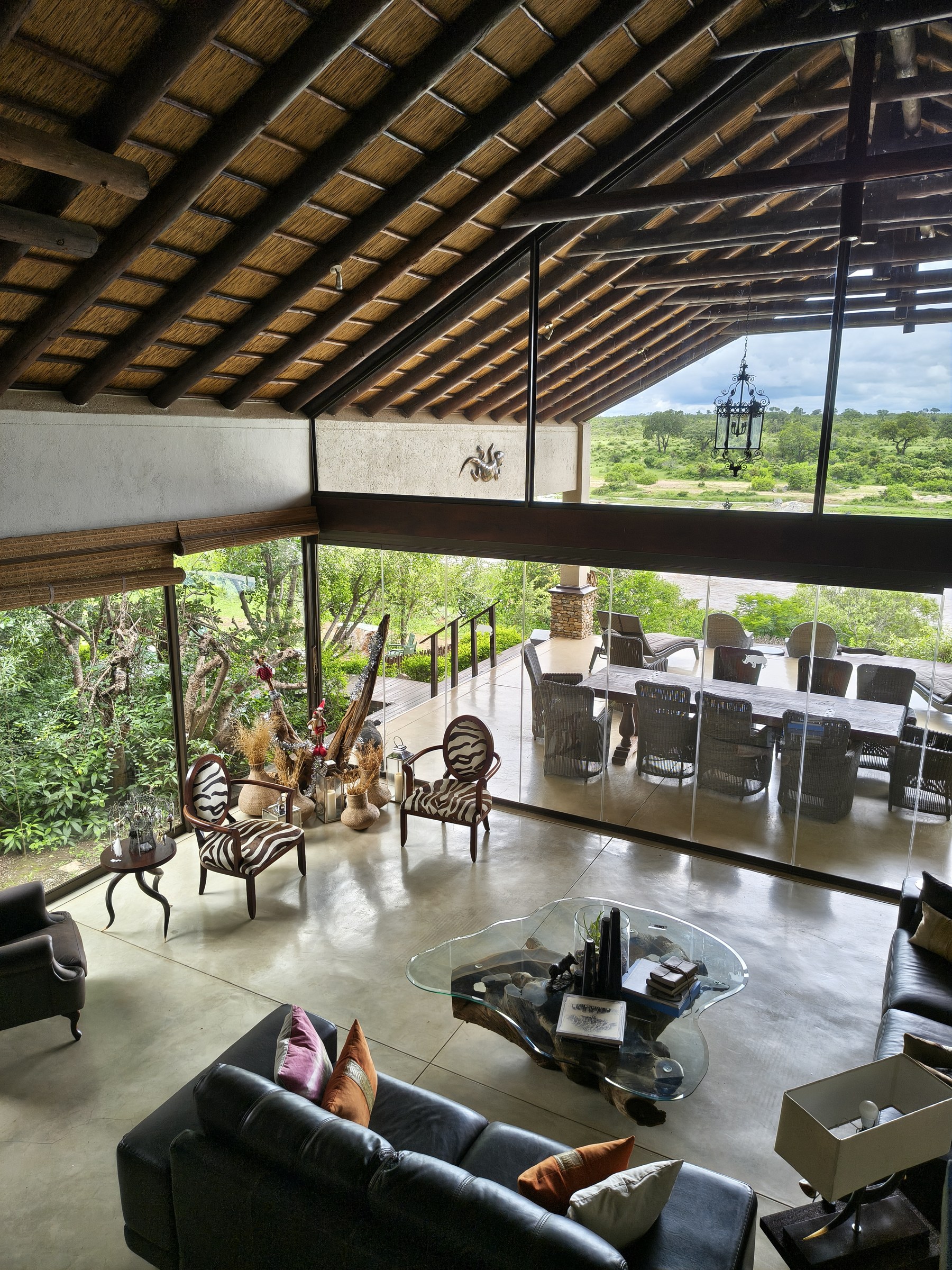 Interior lounge with driftwood table and views across the reserve